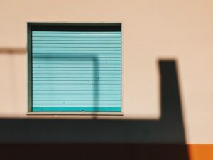 shadow-wall-with-closed-turquoise-shutter-min